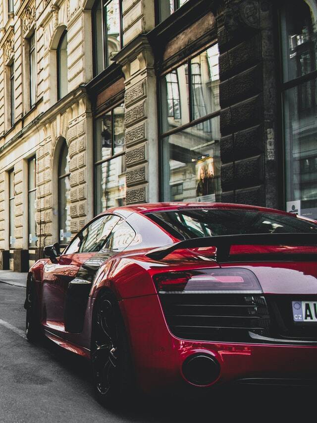 A red sports car parked in front of a building.