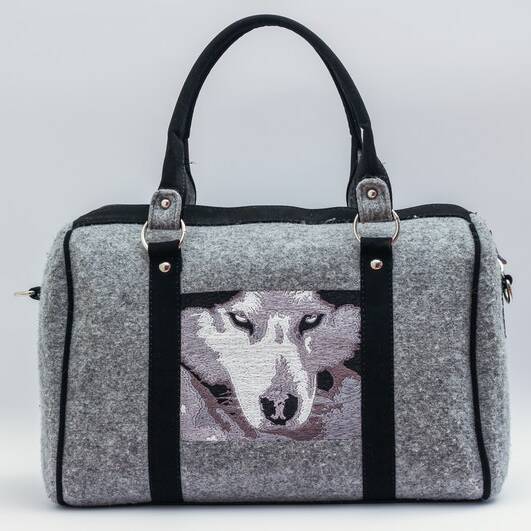 A grey and black bag with a wolf on it.