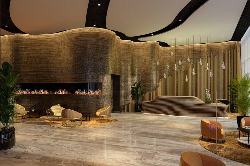 The lobby of a modern hotel with a fireplace.