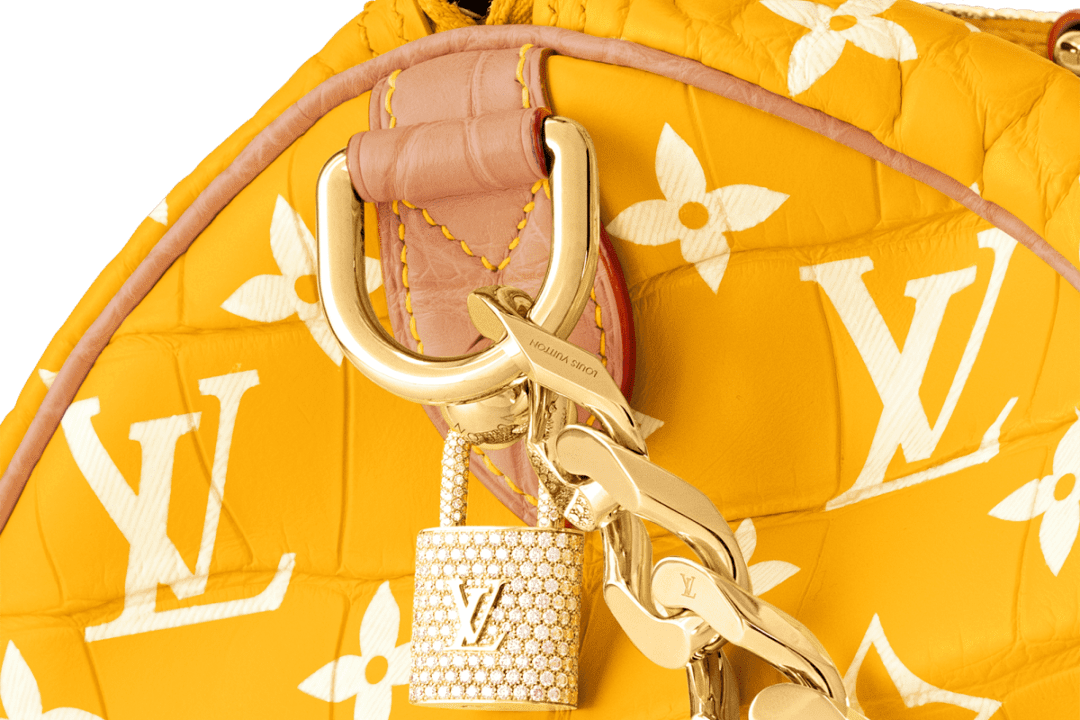 A louis vuitton yellow and white bag with a chain.
