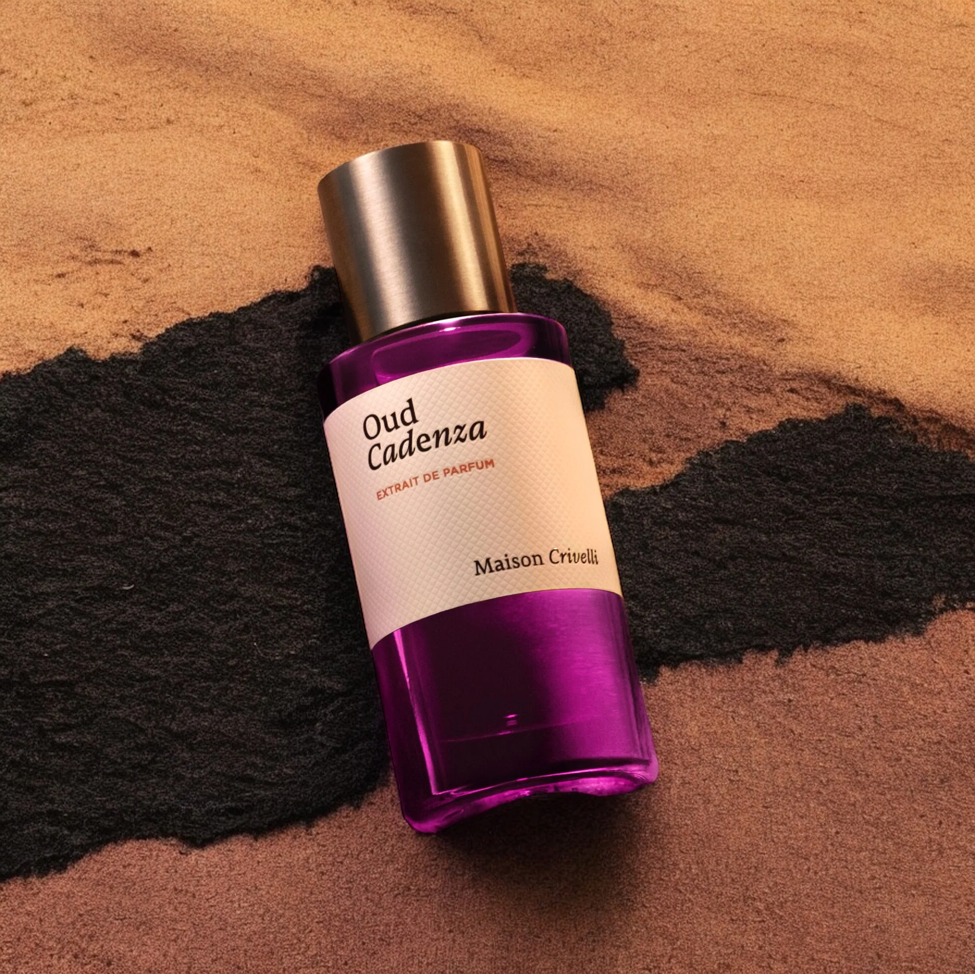 Oud Cadenza perfume bottle on sand.